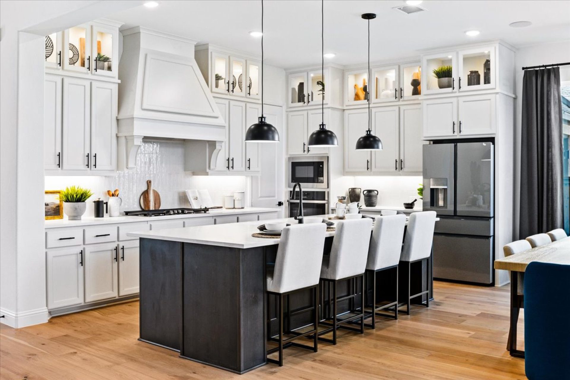 Modern kitchen with custom cabinetry, stainless steel appliances, and quartz countertops by a top home builder in Dallas and Austin.
